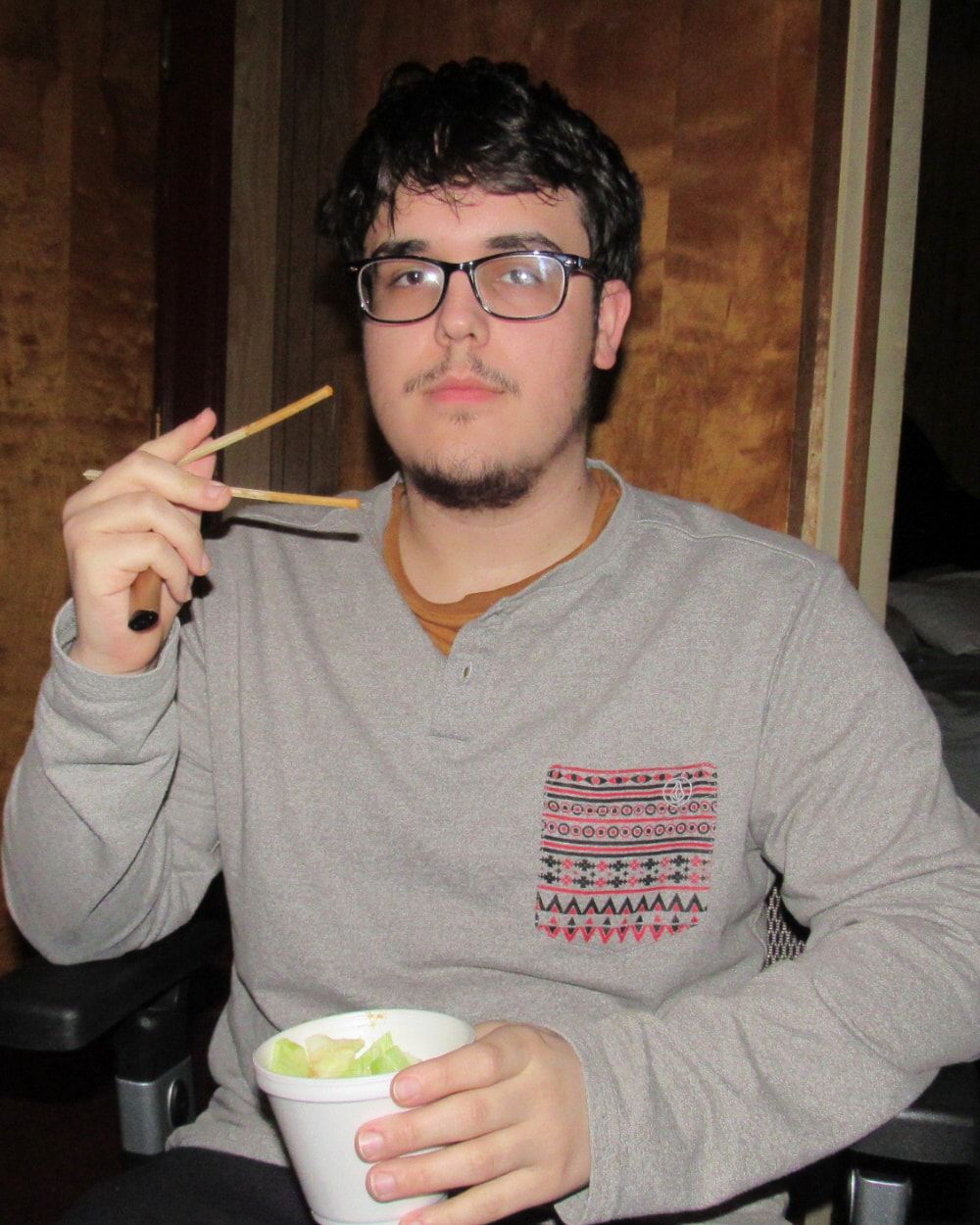 Luke Tarr holding chopsticks and a cup of food